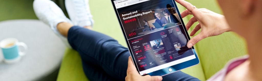 Osoba na zelenom kauču koja pregledava EOS Godišnji izvještaj i Izvještaj o održivosti 2024/25 na tabletu