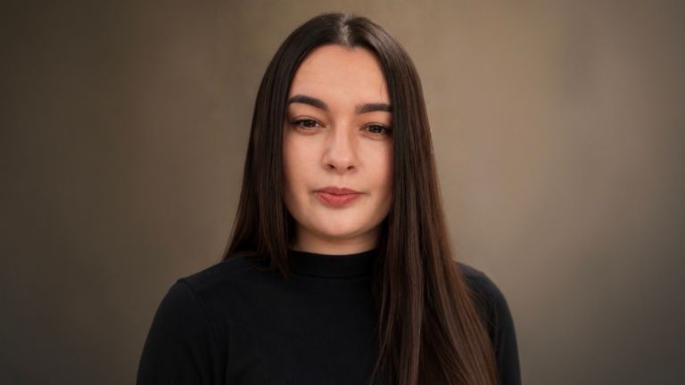 Daniela Moaca, Senior Manager IT u EOS Romania, portretna fotografija u tamnom rolka džemperu.