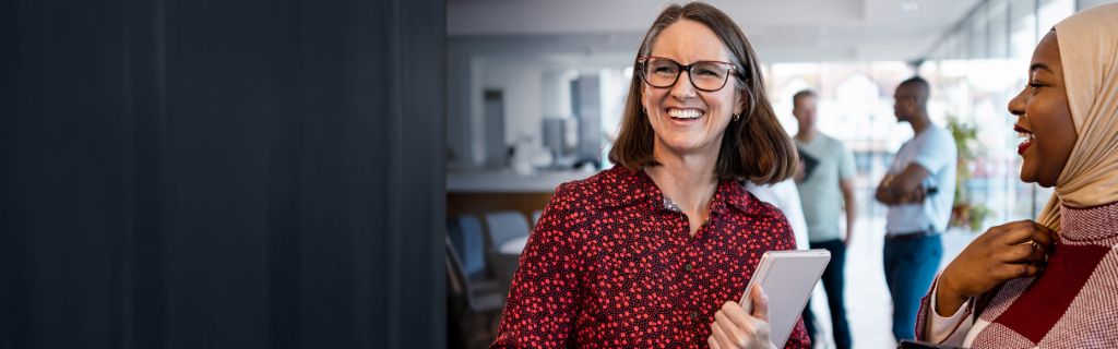 Dvije sretne žene vode neobavezni kancelarijski razgovor