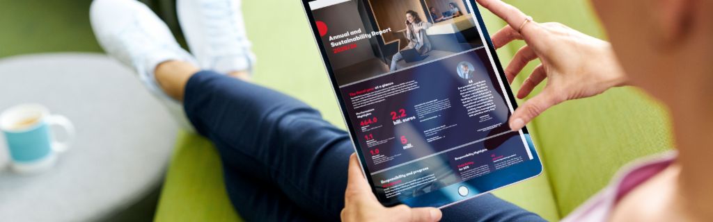 EOS ASR: Slika prikazuje mladu ženu koja drži tablet i na njemu gleda EOS-ov Godišnji izvještaj o održivosti.