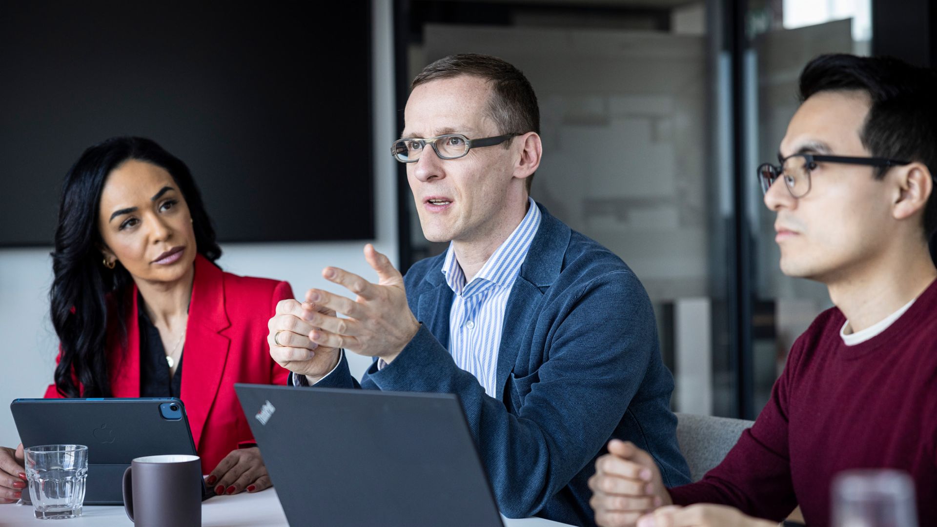 Tri osobe razgovaraju u kancelariji.